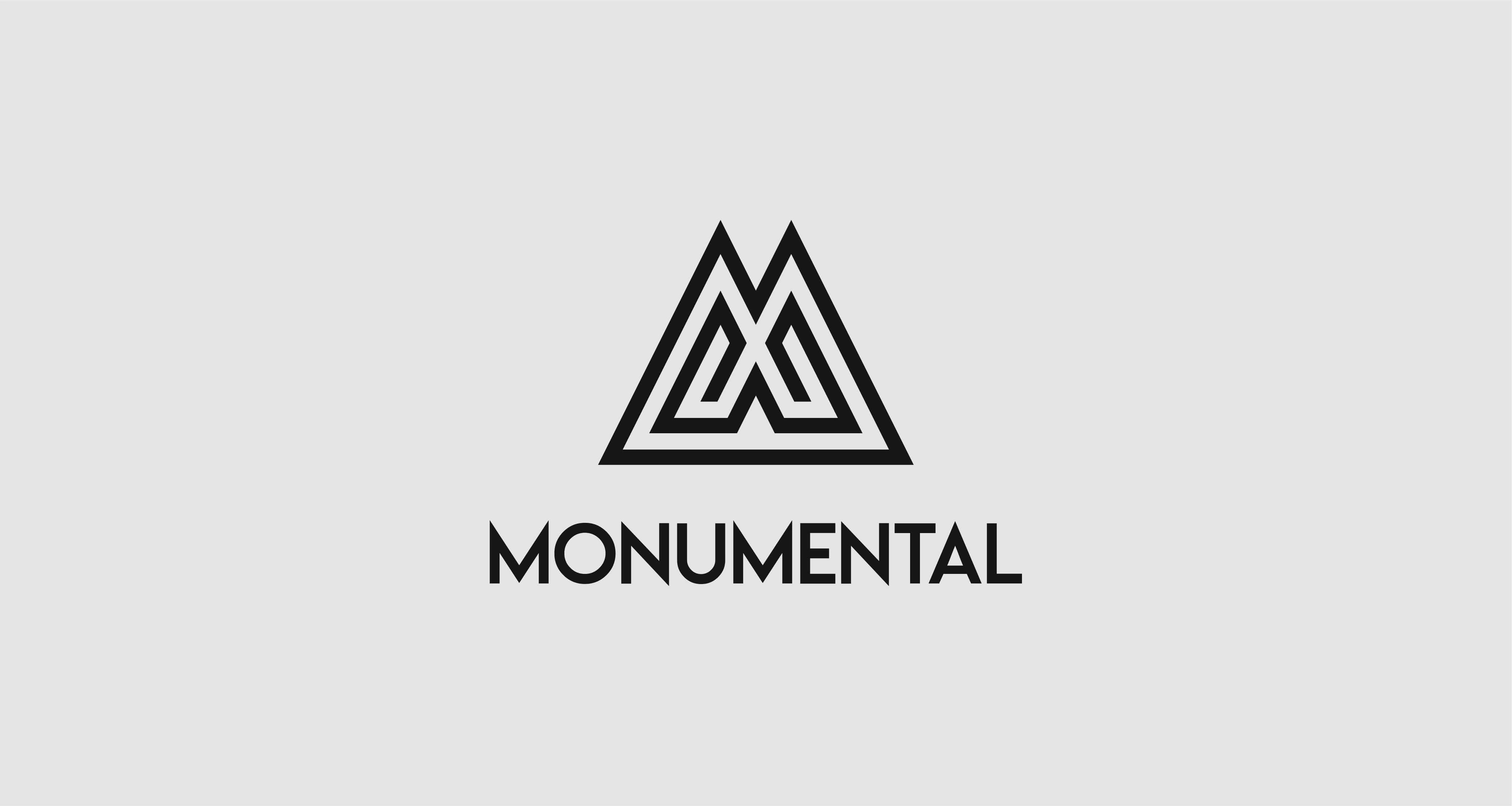 Monumental logo with a geometric mountain mark in black on light grey