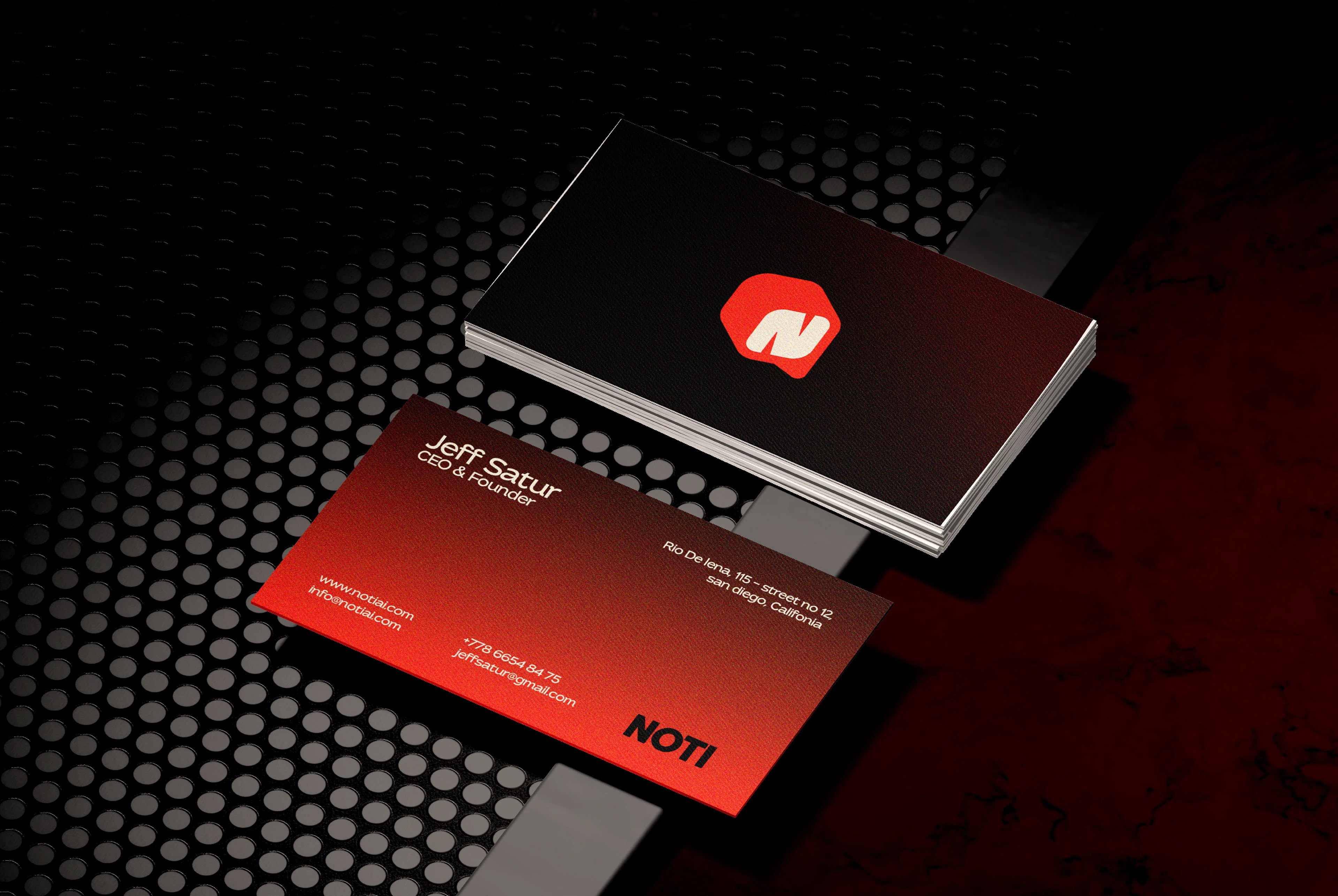 Noti business cards in black and red on a perforated dark surface