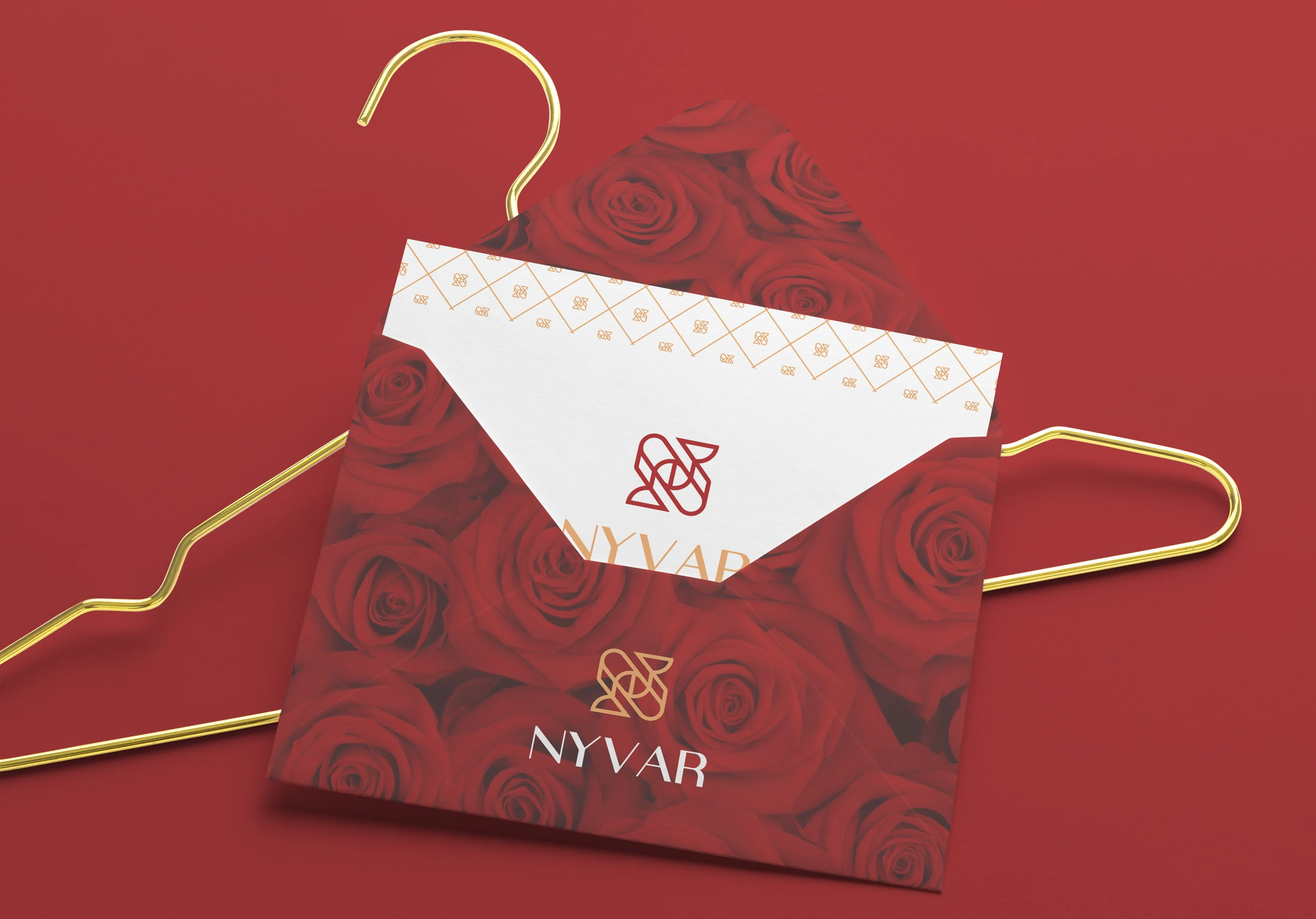 Nyvar rose-print envelope and card hanging from a gold hanger