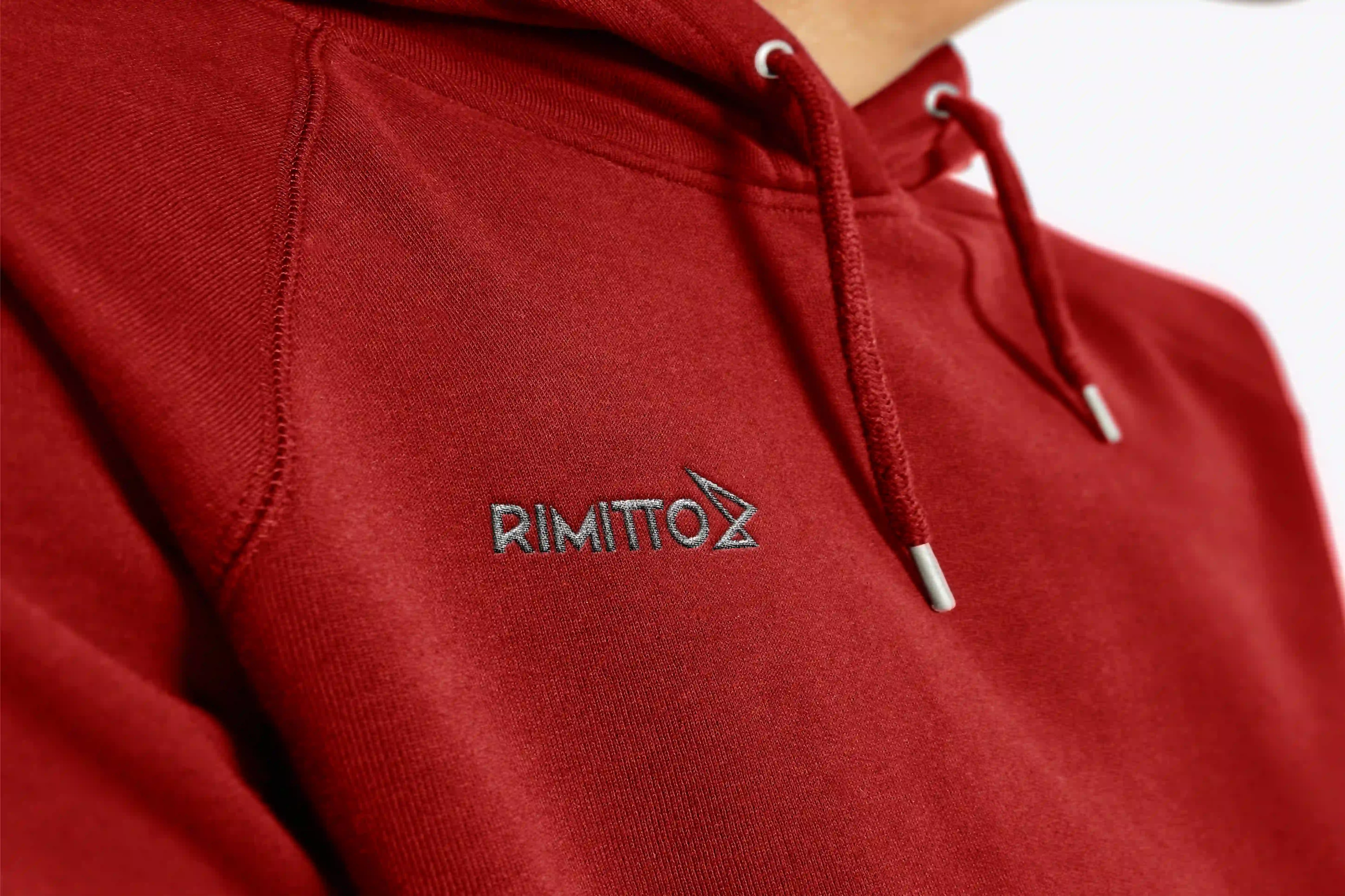 Rimitto logo on the chest of a red hooded sweatshirt