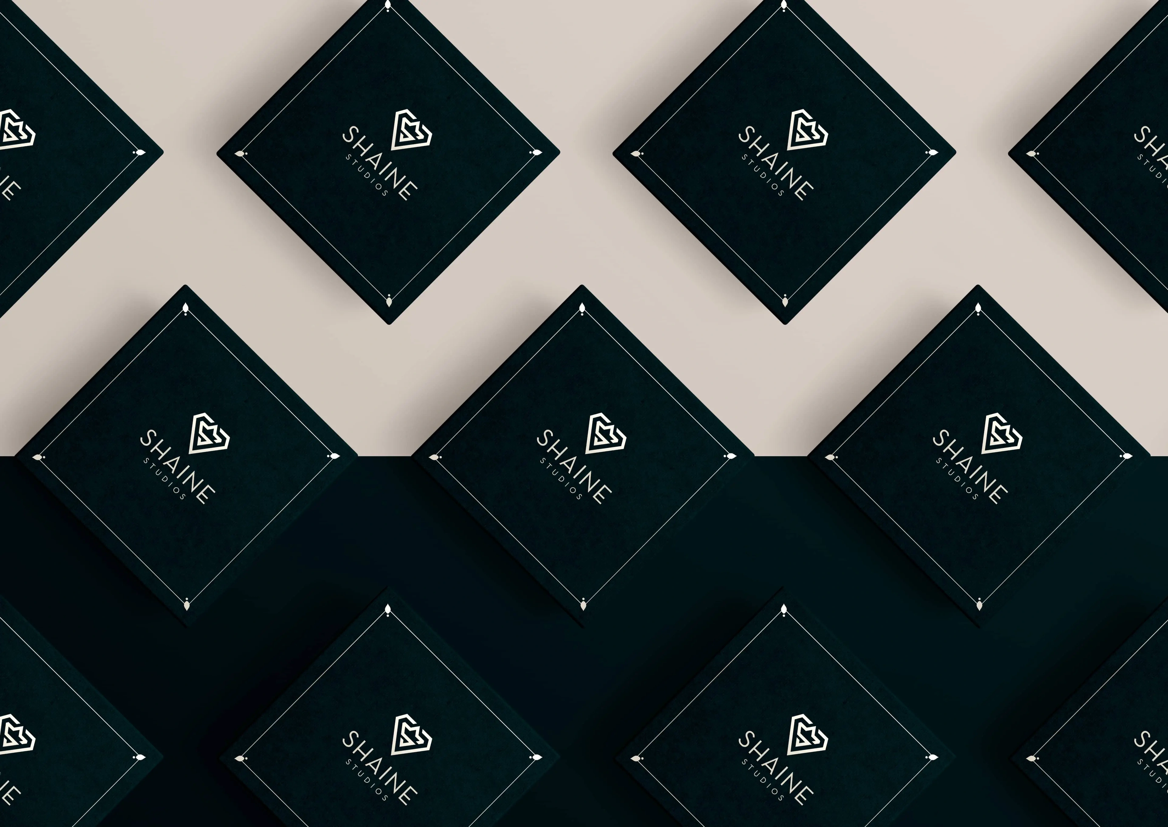 Shaine Studios business cards arranged in a diagonal pattern on dark green