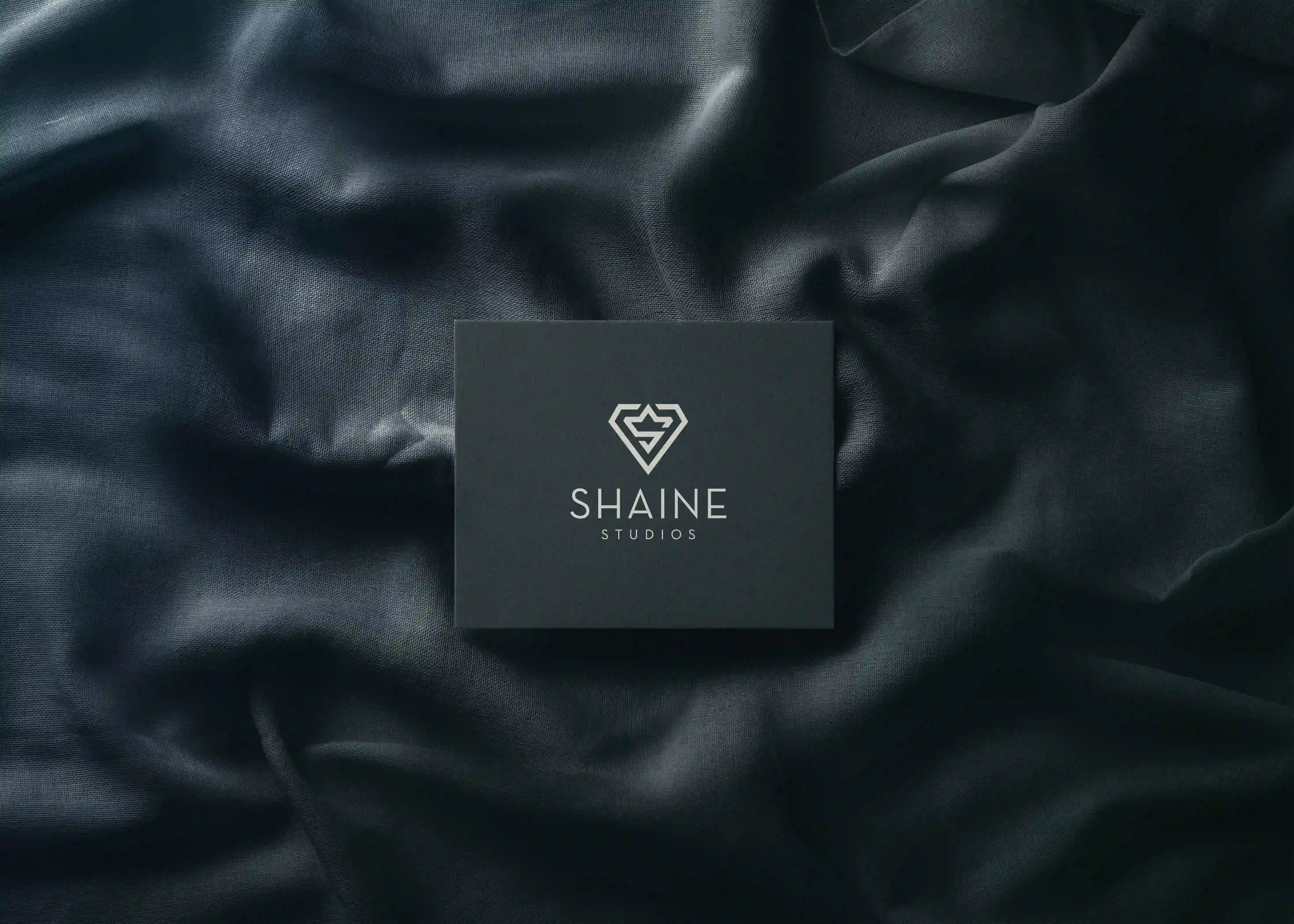 Shaine Studios card on dark folded silk
