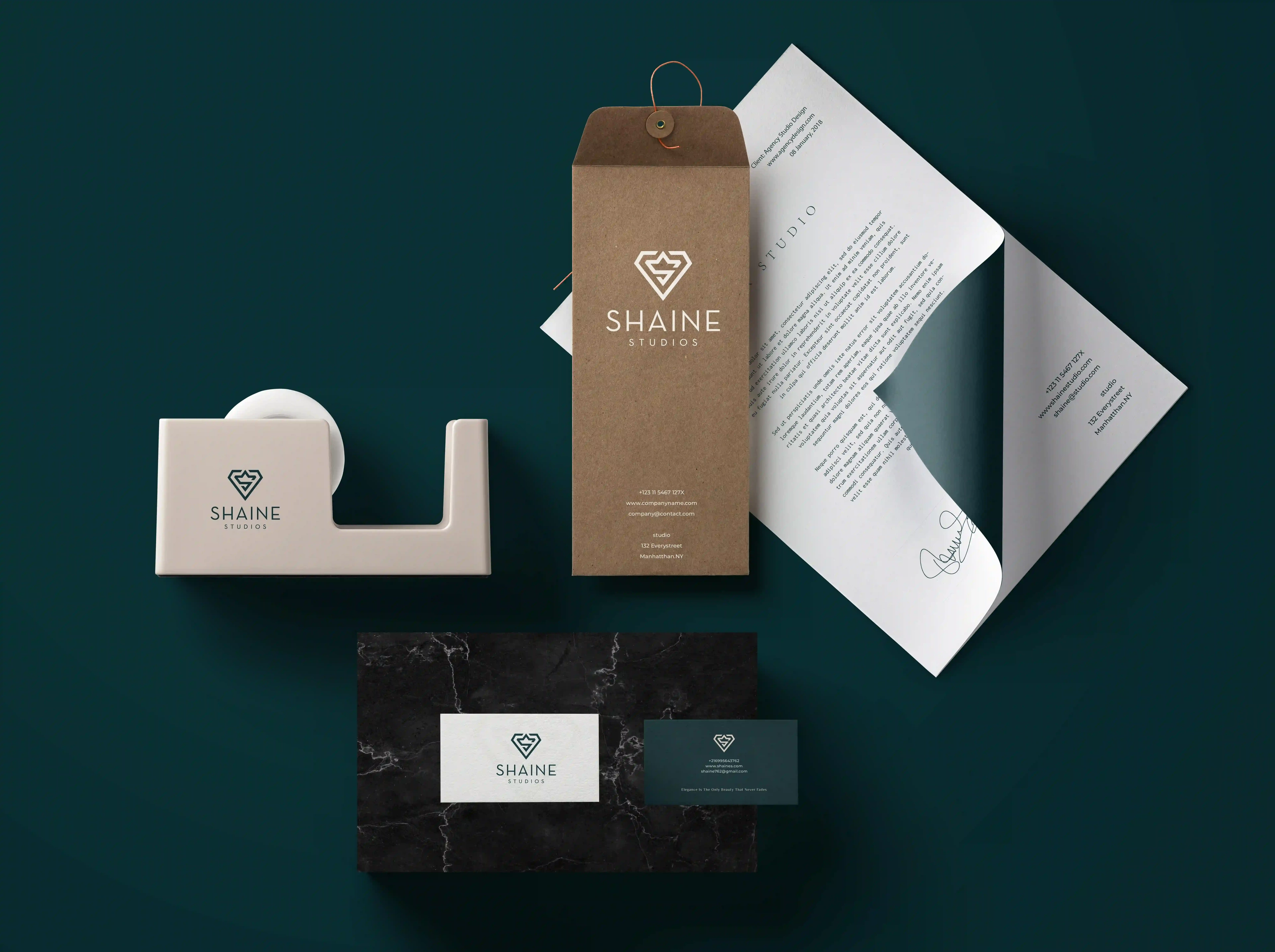 Shaine Studios stationery set with letterhead, kraft tag, tape dispenser and business cards on green