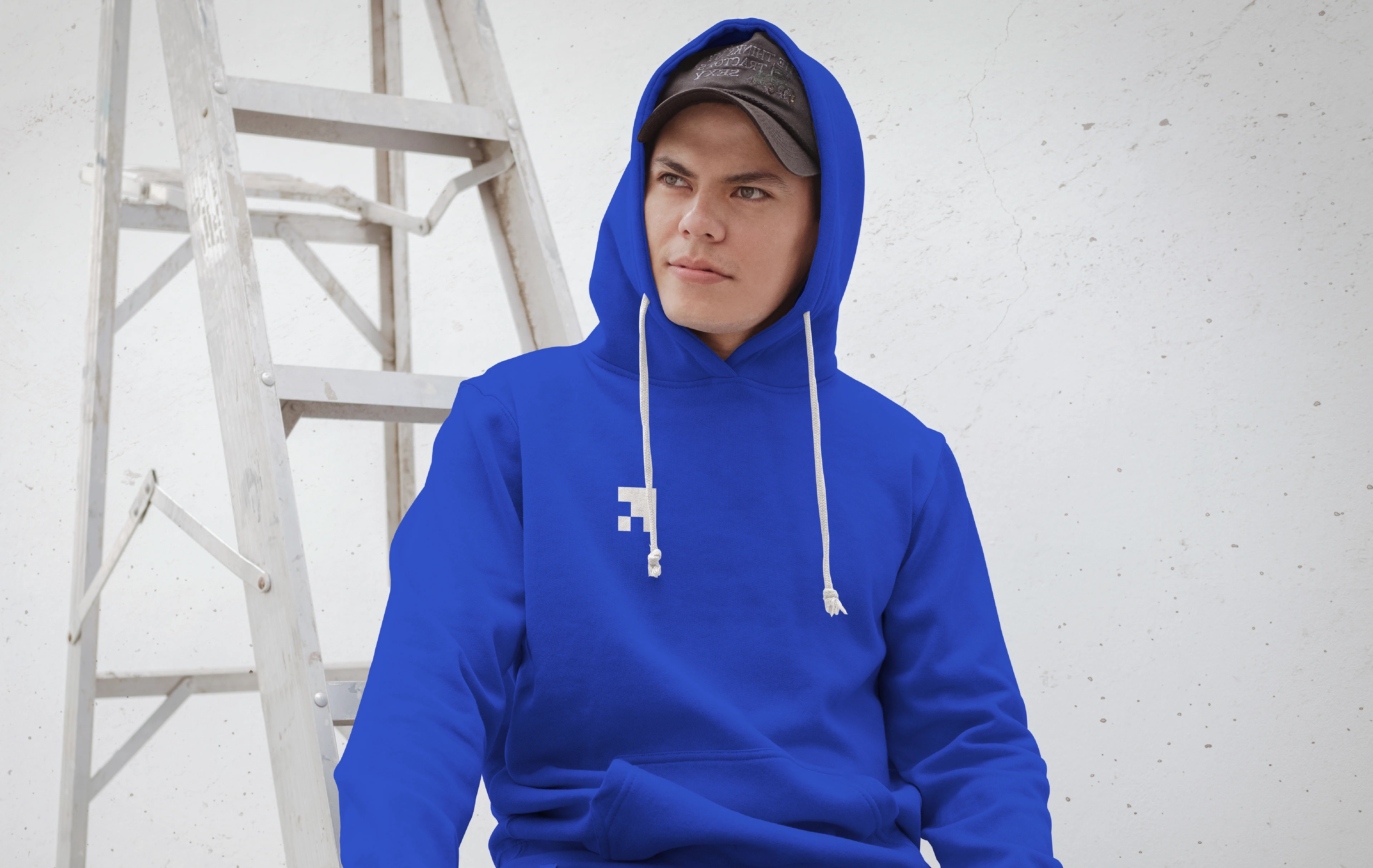 Soar blue hoodie with the logo worn in front of a white ladder